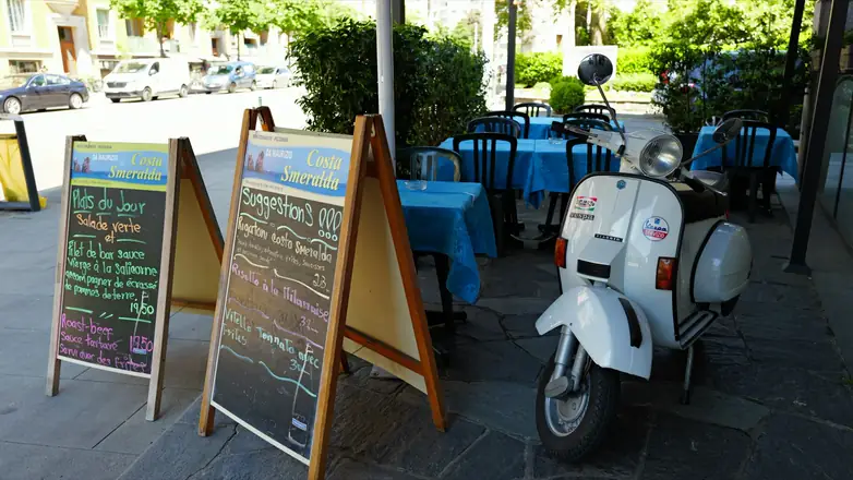 Ardoise du menu et Vespa devant le restaurant